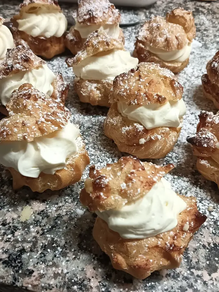 Bignè farciti di panna montata e spolverati di zucchero a velo
