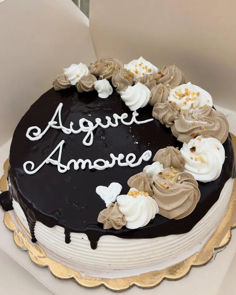 Torta al cioccolato con ciuffi di crema e scritta Auguri Amore
