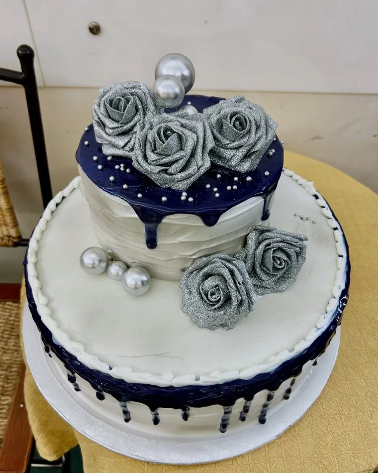 Torta a due piani blu notte con rose argentate e perle