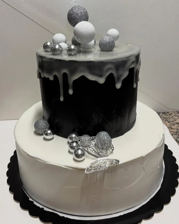 Torta a due piani bianca e nera con perle argentate e farfalle