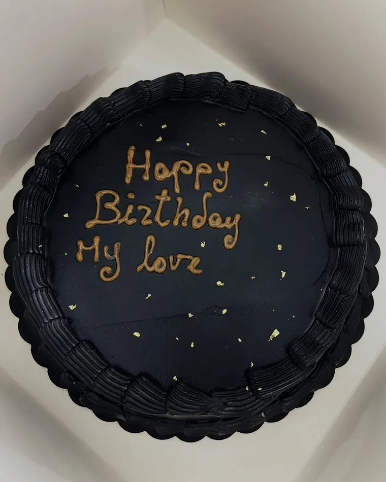 Torta al cioccolato tonda con scritta dorata Happy Birthday